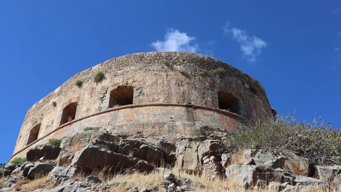 The curved stone bastion of the Venetian sea fortress on Spinalonga island, off eastern Crete